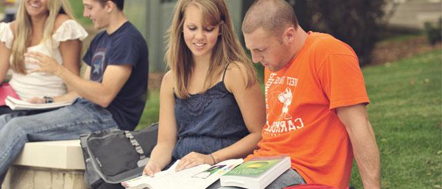 威尼斯游戏大厅 students sitting reading a book together.